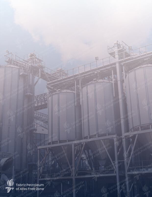 A modern chemical facility, with towering distillation towers and intricate pipelines, where hydrogen peroxide is produced and stored safely.